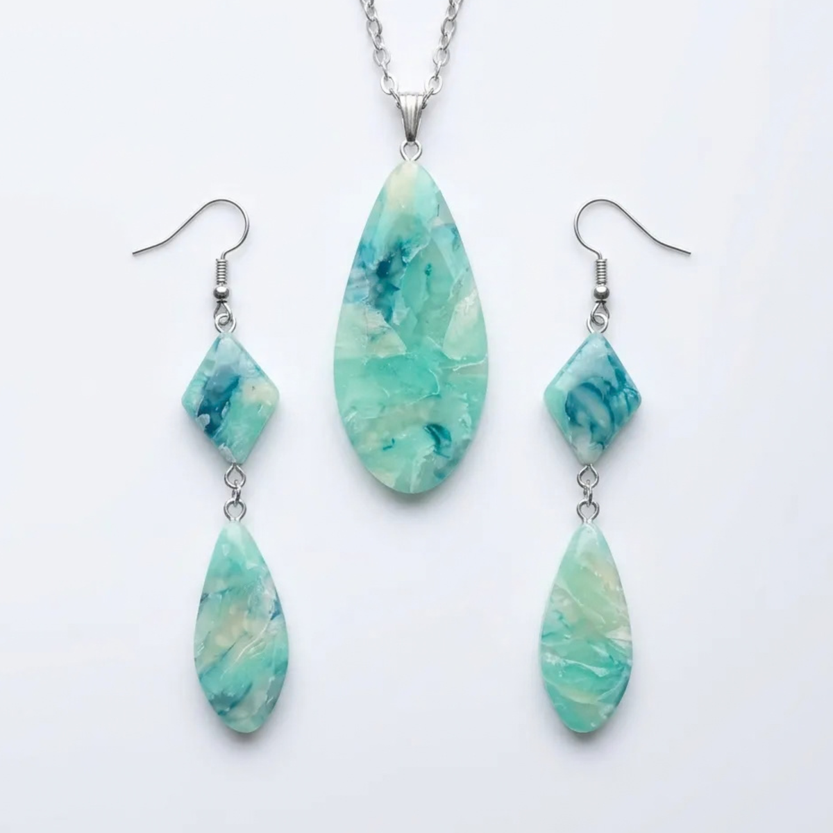 "A Diddit Aquamarine jewellery set featuring a silver necklace and matching drop earrings with marbled aqua and teal stone pendants, displayed on a clean white background."